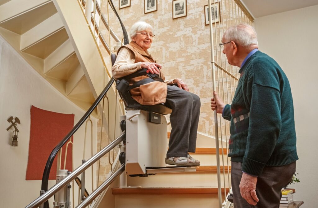 A senior couple tests out their new stairlift at home.