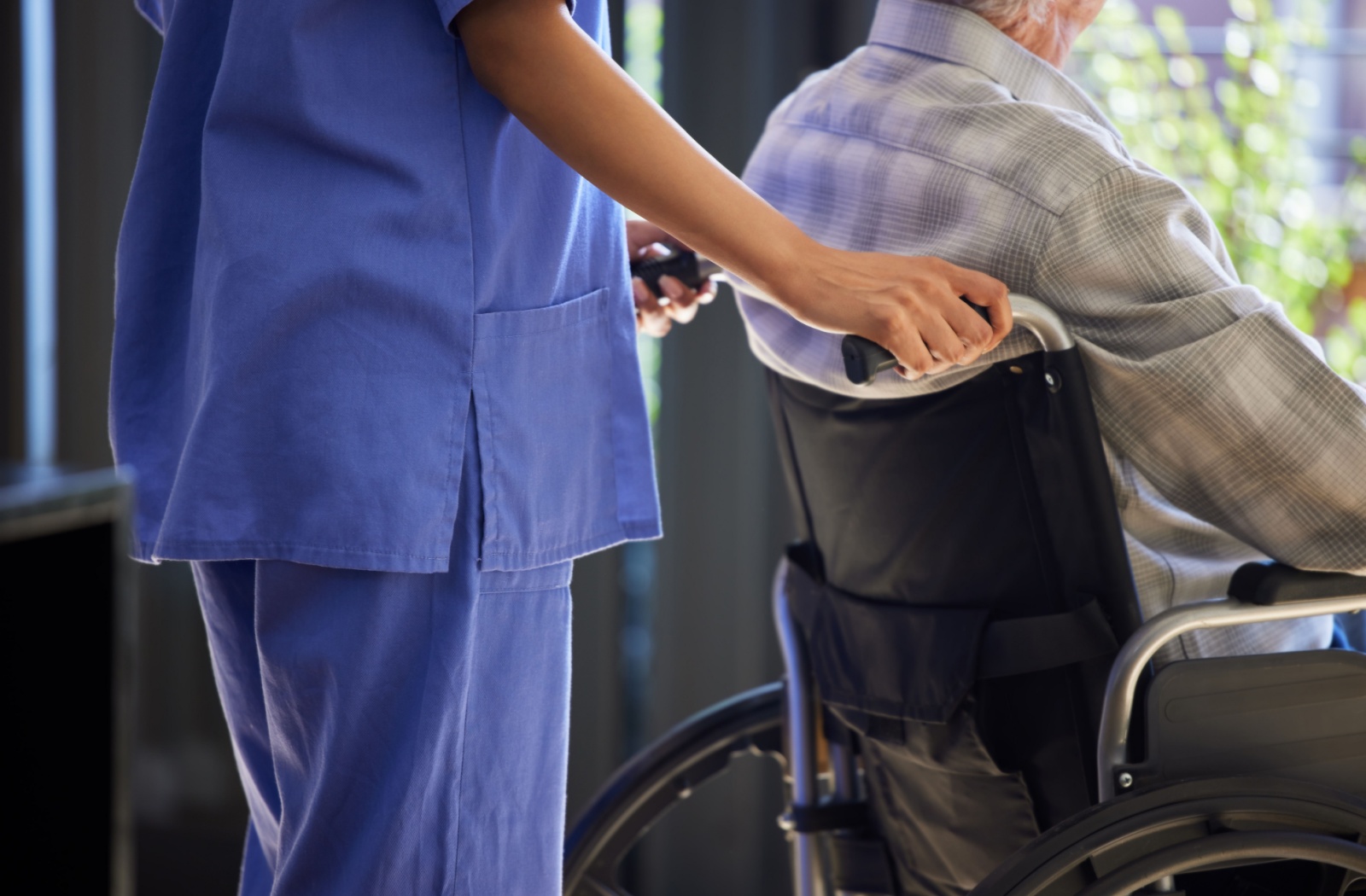 A caregiver helps a senior in assisted living with age-related mobility issues.