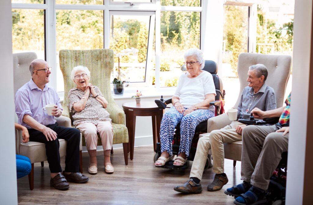 A group of seniors in assisted living laugh and enjoy each other's company.